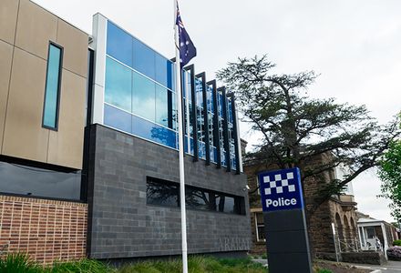 A police station in Victoria with a flagpole at the entrance.