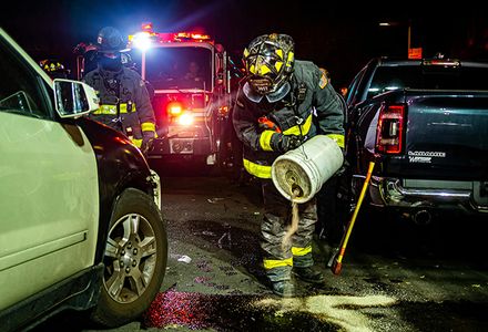 A firefighter cleans up a chemical spill at a road accident.
